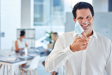 Image showing Covid, health and freedom, mask off for man in office after lockdown. Portrait of a happy businessman putting a face mask on to curb spread of virus in workplace and protect employees from infection.