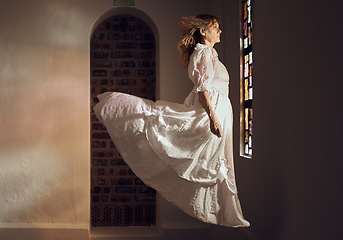 Image showing Ghost of senior woman, looking at stained glass and floating over floor of building or cathedral. Elderly soul, phantom or dead spirit staring at beautiful window at a chapel or church after funeral