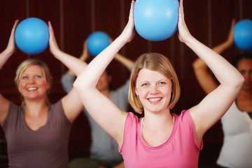 Image showing Pilates, fitness and training of a happy woman in a health and wellness class in a yoga studio. Ball workout and exercise of a relax female from Germany with a smile trying to be healthy at a gym