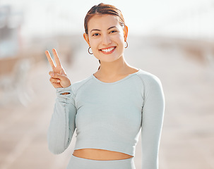 Image showing Peace sign hand, fitness woman or motivation for wellness health goals in exercise, training or sports workout. Happy smile portrait of personal trainer, cool gesture and athlete runner on background