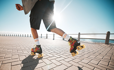 Image showing Person roller skating, sport and fitness on a sidewalk, sea or ocean shore. Sun flare, exercise and sports with roller skate cardio workout, training for wellness, strength and health on promenade.