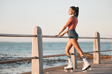 Image showing Summer, roller skate and black woman at beach promenade for fitness freedom, fun exercise and hobby training. Relax, calm and sunshine nature with young skating culture, cool urban girl and sea youth