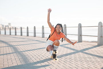 Image showing Fashion black woman, roller skating or fun by beach, sea or ocean brick street in Miami, Florida. Portrait of smile, happy or playful student with trend, style or cool clothes in freedom sports stunt