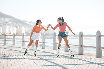 Image showing Black women, fist bump and roller skating happy friends by the sea, ocean or shore outdoors. Support, partnership and girl team collaboration or fun while traveling down promenade together.