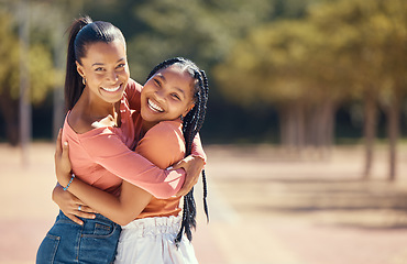 Image showing Portrait of happy friends hugging and smile outside in the park. Happy african american females embracing each other, spending the day together in the forest, enjoying a fun time during summer