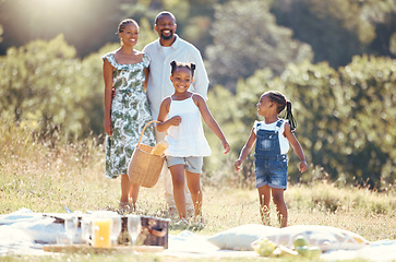 Image showing Black family, summer picnic and children bond with parents on break in remote countryside park field. Smile, happy and love mother, father or playful and fun girls in nature outing with man and woman