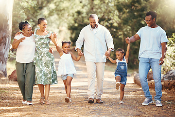 Image showing Black family, hiking or bond with children, parents or grandparents walking in remote nature forest and countryside. Happy mother, father or senior holding hands with girls and skipping in tree park