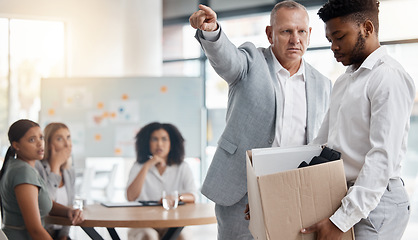 Image showing Black man, sad and fired by boss in a meeting holding a box in disappointment at the office. Manager or company leader pointing to the exit and firing employee in front of colleagues at the workplace