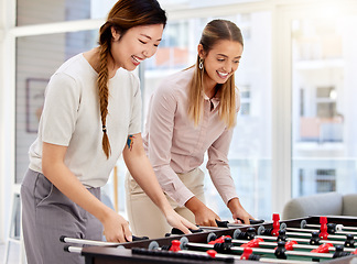 Image showing Business women playing table soccer, laughing and having office fun at their corporate job. Diverse female colleagues bonding while competing in a friendly foosball game during a break together