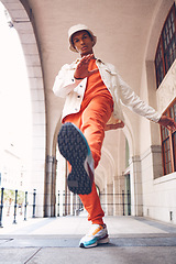 Image showing Fashion, model and gen z man from Spain with neon, trendy and luxury brand clothes. Clothing brand and leg kick pose of a hipster Spanish person with sports shoes posing by a building outdoors