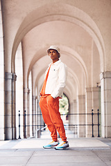 Image showing Fashion portrait, cool and black man posing in a city arch building. Stylish lifestyle, retro and handsome creative person or designer model in fashionable, fancy and edgy hat, shirt and pants.