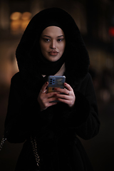 Image showing Muslim woman walking on urban city street on a cold winter night wearing hijab