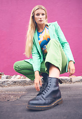 Image showing Fashion content creator and social media influencer in neon clothes and cool modern pose outdoors on the road. Photography, green and portrait of a young woman on the city street against a pink wall