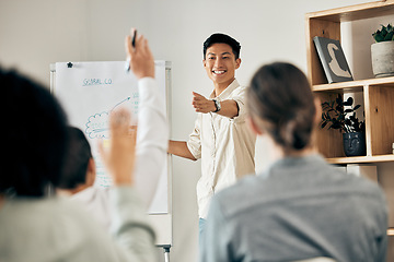 Image showing Businessman doing a presentation in a meeting with his team asking questions in a conference room. Group planning a project on a flip chart in an office. People at a corporate seminar or workshop.