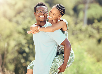 Image showing Love, date and outdoor couple in park or romantic nature outing for healthy, green lifestyle with trees, bokeh and lens flare. Happy, wellness black people and caring man giving woman piggyback ride