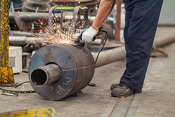 Image showing Worker using an angle grinder, making a screw conveyor