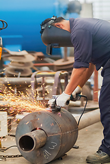 Image showing Worker using an angle grinder, making a screw conveyor