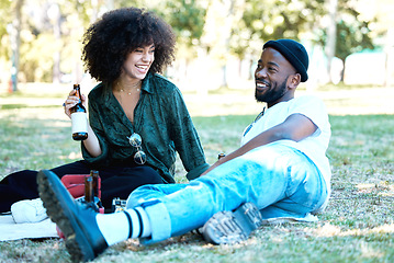 Image showing Interracial couple in nature park together, man and woman relax with drink on grass and happiness for people on picnic date outside. Happy black friends dating, laughing and having fun on weekend