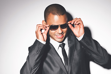 Image showing Fashion, model from Brazil and sunglasses in a studio in a luxury business suit looking cool. Attractive man on set with a white background and happy smile modeling for a rich designer glasses brand