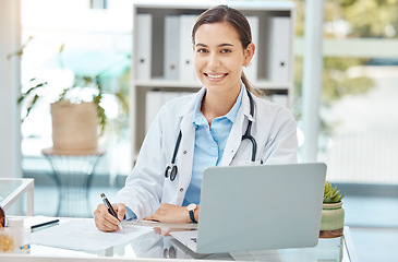 Image showing Healthcare, medicine and a doctor writing on insurance document or patient file. Happy woman working in medical field, at desk with laptop consulting online and filling in a script at hospital office