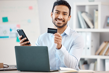 Image showing Credit card, phone payment and businessman shopping on the internet, banking on mobile app and working in finance in work office. Portrait of smile Asian employee using online retail service on web