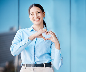 Image showing Heart, love and health with the hands of a business woman making a gesture with a smile outside in the city. Portrait of a corporate female employee showing affection and standing alone outdoors