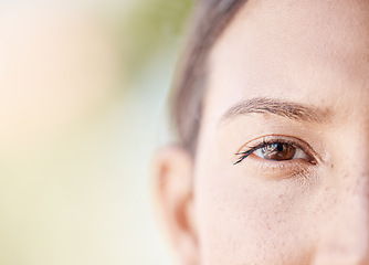 Image showing Face portrait of a woman eye thinking with mockup or blurred background with bokeh. Head of a serious or focus young female with light freckle skin, staring with brown eyes outdoors in nature