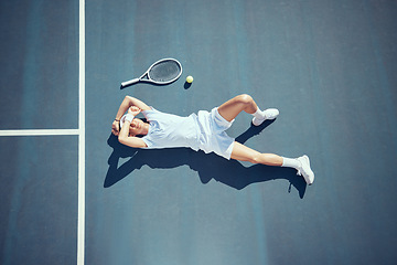 Image showing Tired tennis sports loser man on floor with racket, ball and court in summer sun from above. Relax and fitness player lying on ground, resting or taking break after match, game or outdoor practice