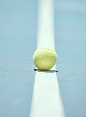 Image showing Tennis ball on the floor of a sports court during practice for a match in summer outdoors. Closeup of equipment for athlete team to train their strategy and skill for exercise and a game at stadium.