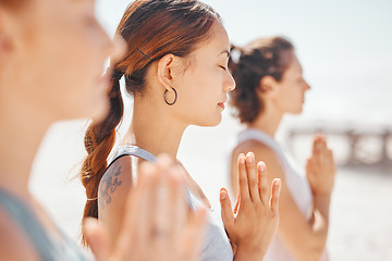 Image showing Women friends meditation while training yoga exercise on the beach. Group of zen female athlete working out outside with inner peace, balance and getting healthy or wellness on a fitness lifestyle