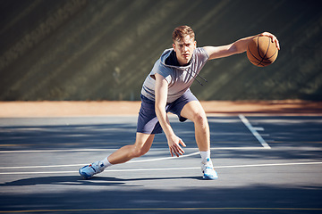 Image showing Portrait, sport and basketball man on court in training, practice or game. Health, exercise and workout male athlete showing off skills, getting ready for sports competition or tournament outside.