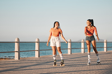 Image showing Friends roller skating on the promenade at the beach during a summer vacation in South Africa. Happy, active and young girls doing a fun activity in nature on the ocean boardwalk while on holiday.