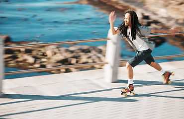 Image showing Freedom, energy and roller skating with black man training and exercise along a beach outdoors. Active African American enjoying intense speed practice of fitness hobby, cardio and balance workout