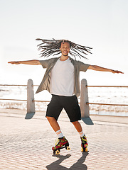 Image showing Training, sports and skate with a man roller skating on the promenade by the beach with the sea in the background. Fitness, fun and freedom with a young male on roller skates outside in summer