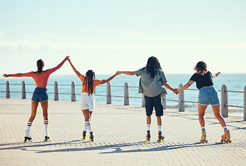 Image showing Roller skaters, friends and holding hands at a beach for exercise, fitness and freedom in summer together. Group, male and young girls skating on sidewalk at sea to relax on outdoor holiday vacation