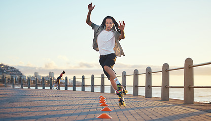 Image showing Roller skating, man and fun sports by ocean, sea or beach in Florida in freedom exercise, workout drill and training at sunset. Fashion or cool local in wellness fitness skill in city park or street