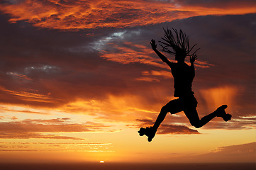 Image showing Sunset sky, silhouette and roller skates woman jumping against an orange horizon while enjoying freedom, travel and fun while skating. Energy, scenery and beauty of nature while out on an adventure