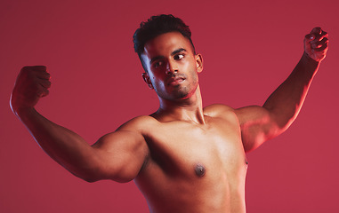 Image showing Bodybuilder, muscle and fitness with a nude man model posing shirtless in studio with a red background. Naked, strong weightlifter with a healthy male flexing arms inside for health and wellness