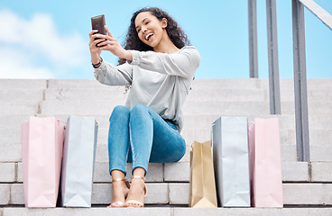 Image showing Selfie, shopping and female influencer and blogger sitting outside with bags after a spending spree while on city stairs. Happy, consumer or customer live streaming fashion sale and promotion offer