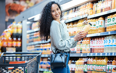 Image showing Portrait of a woman with juice while shopping in a grocery store with a retail product sale. Happy customer with a wellness, health and diet lifestyle buying healthy groceries at a supermarket.