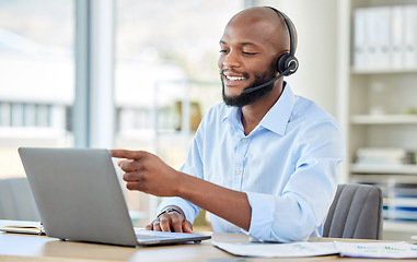 Image showing Call center, black man on laptop and video call with headset consulting, customer service or support. African sales man, crm telemarketing or contact us, work or consultant operator at the office.