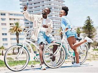 Image showing Selfie, bike and date with a couple cycling on a promenade during summer with love, romance and affection. Bicycle, photograph and fun with a black woman and man outside and a city in the background