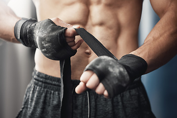 Image showing Training, fitness and boxing man prepare for workout or match at gym or fitness center with hand wrap. Closeup of athletic boxer getting ready for strength, cardio and endurance kickboxing challenge