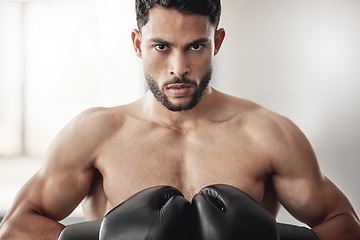 Image showing Fighter, sport and boxing gloves on strong man or athlete boxer doing serious training, exercise and muay thai in gym or fitness club. Portrait, wellness and fighting arab professional ready to fight
