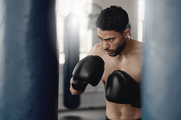 Image showing Boxing man, punching bag and strong power, focus mma and fighter training challenge in gym club, exercise and combat sports. Fitness champion, healthy warrior athlete and pro boxer gloves hit impact