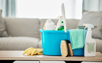 Image showing House, cleaning service and container with spray bottle, rubber gloves and scrub in home living room or apartment interior. Spring clean day, career or housekeeping with household products on table