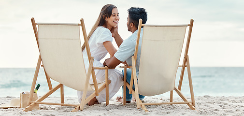 Image showing Happy, travel and love of a couple from India on a beach, ocean and sea vacation. Happiness of Indian people smile with a peace, relax and calm mindset together by the waves, sand and water in nature