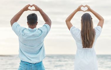 Image showing Couple hands, back heart love sign and passion, affection or romantic emoji by the ocean. Romance, man and woman, hand symbol or emotion shape. Intimacy or adoration, support or devotion gesture.