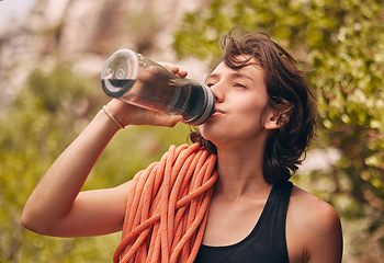 Image showing Water bottle, hiking and exercise with woman feeling thirsty and staying hydrated during fitness workout or rock climbing in nature. Health, wellness and electrolyte with athlete female on adventure