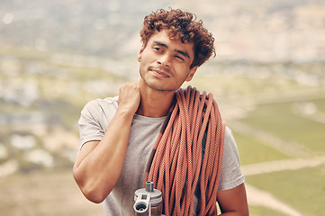 Image showing Man on a mountain rock climb or hike trip with a rope and water bottle outdoors in nature. Young, healthy and active guy on a fitness adventure with neck pain to explore with safety equipment.